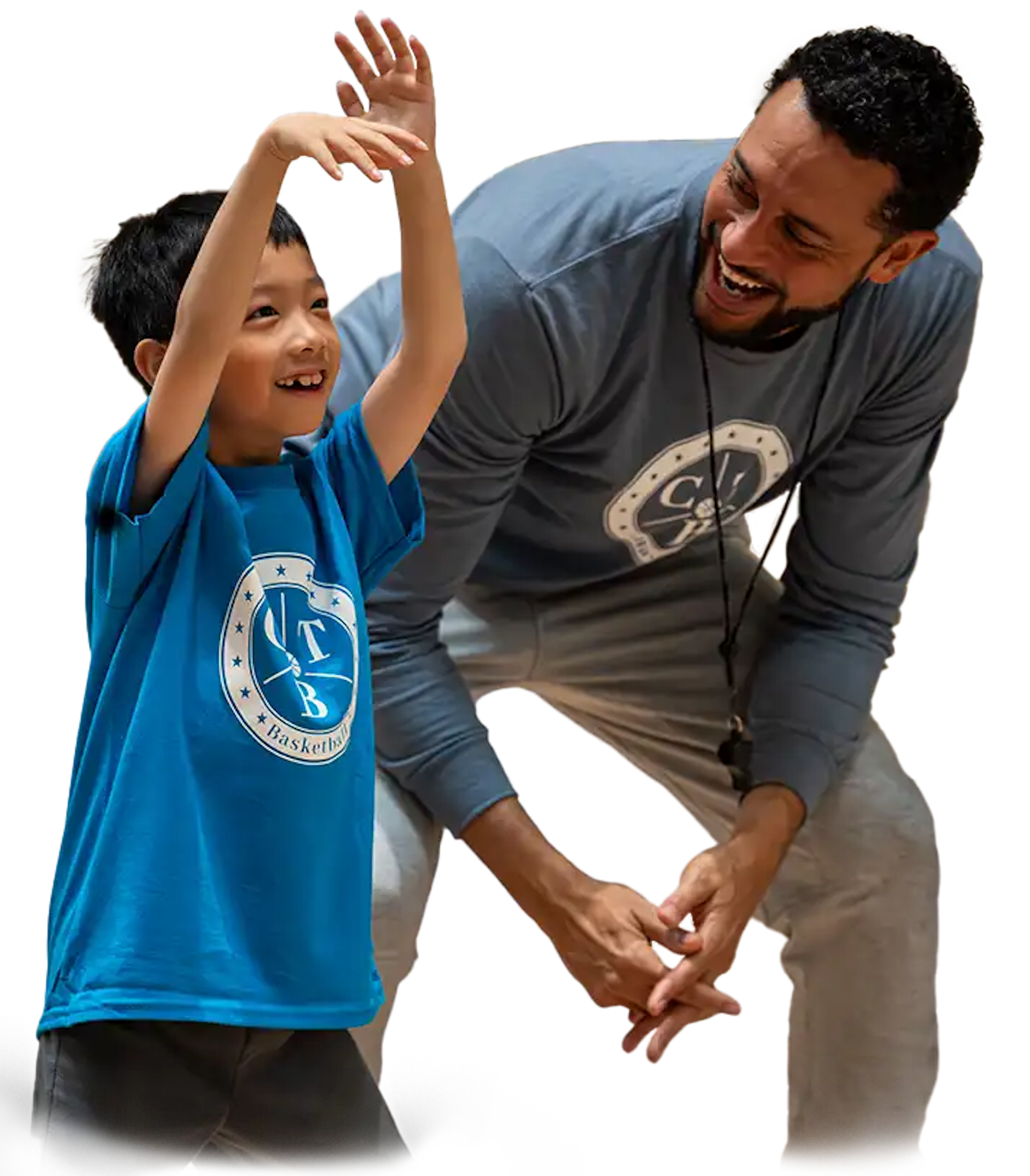 A coach teaching a young boy how to shoot a basketball